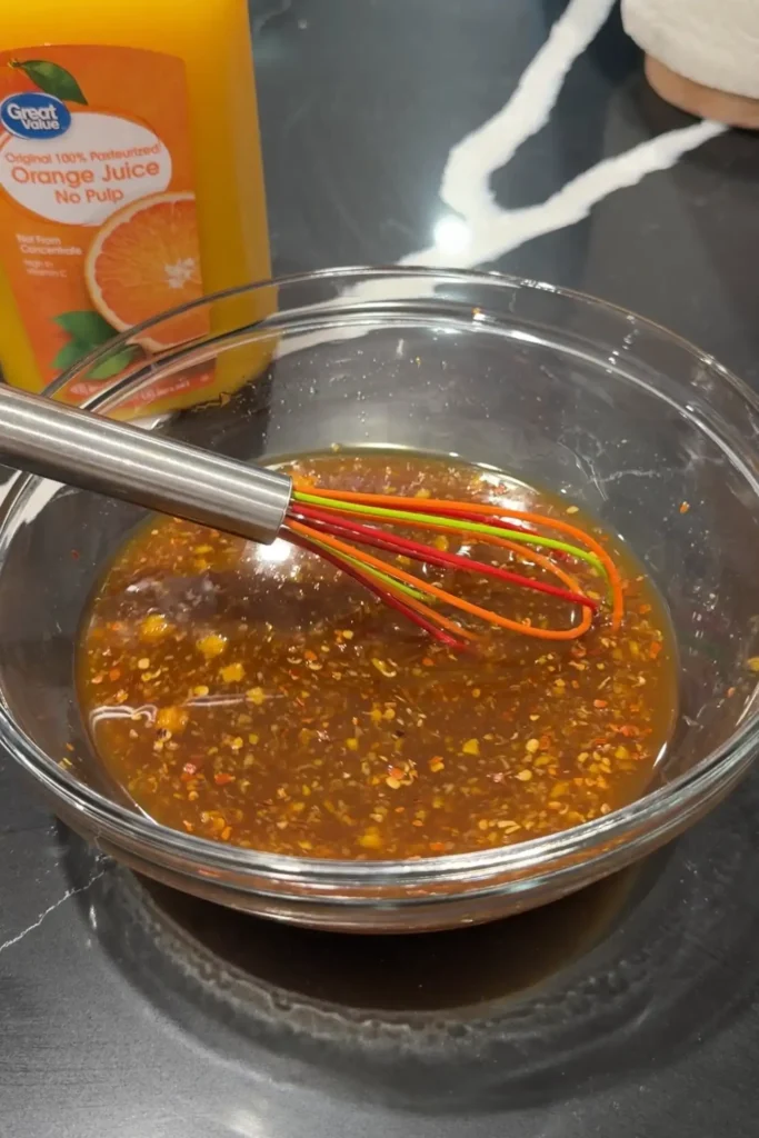 Whisking together the orange sauce ingredients until the mixture is smooth and well combined.