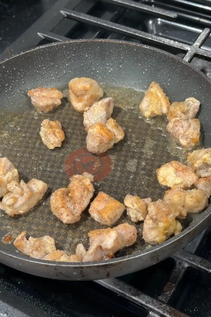 Pan-frying chicken until golden brown and crispy on all sides.
