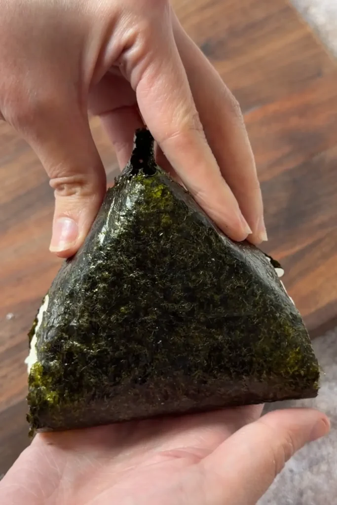 Finished salmon onigiri wrapped in nori and ready to serve as a portable Japanese snack