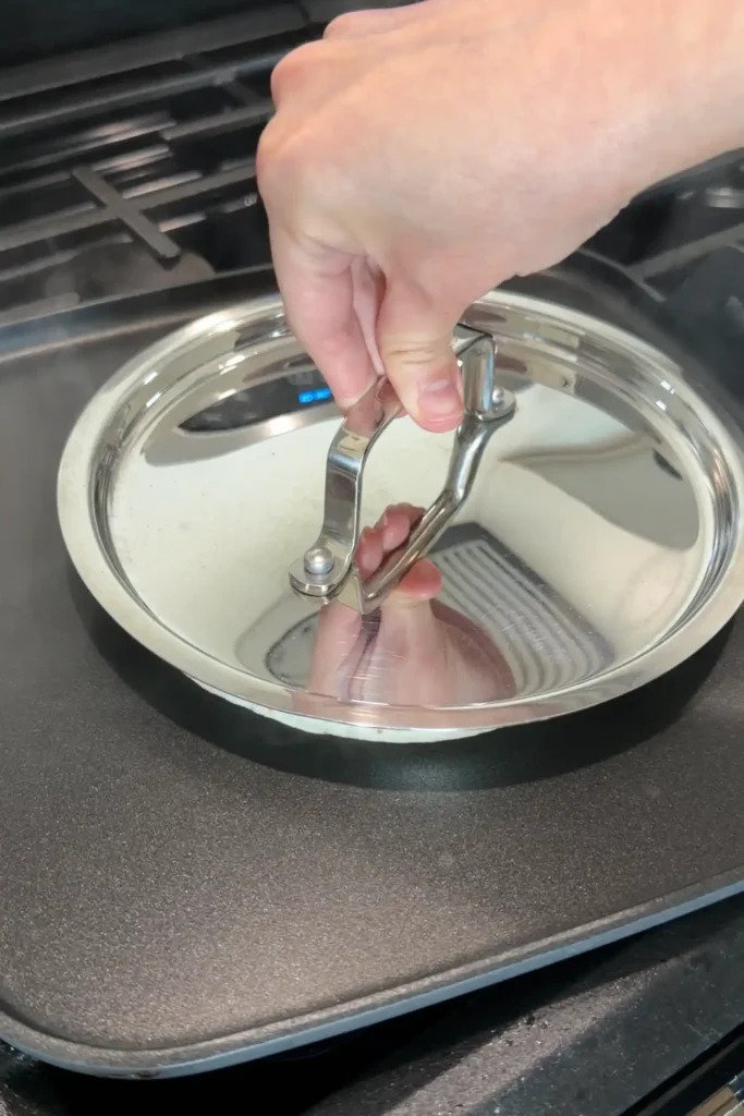 Covering smash burger tacos with a lid while cooking on a griddle