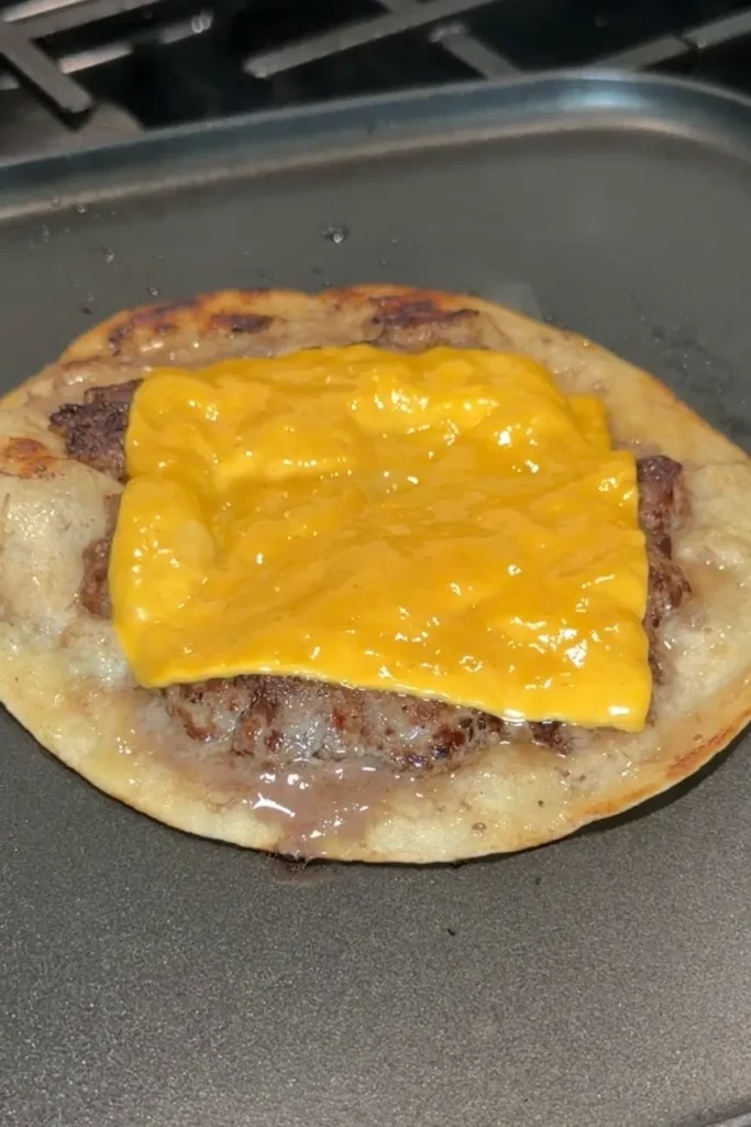 Melted American cheese covering a smash burger taco patty