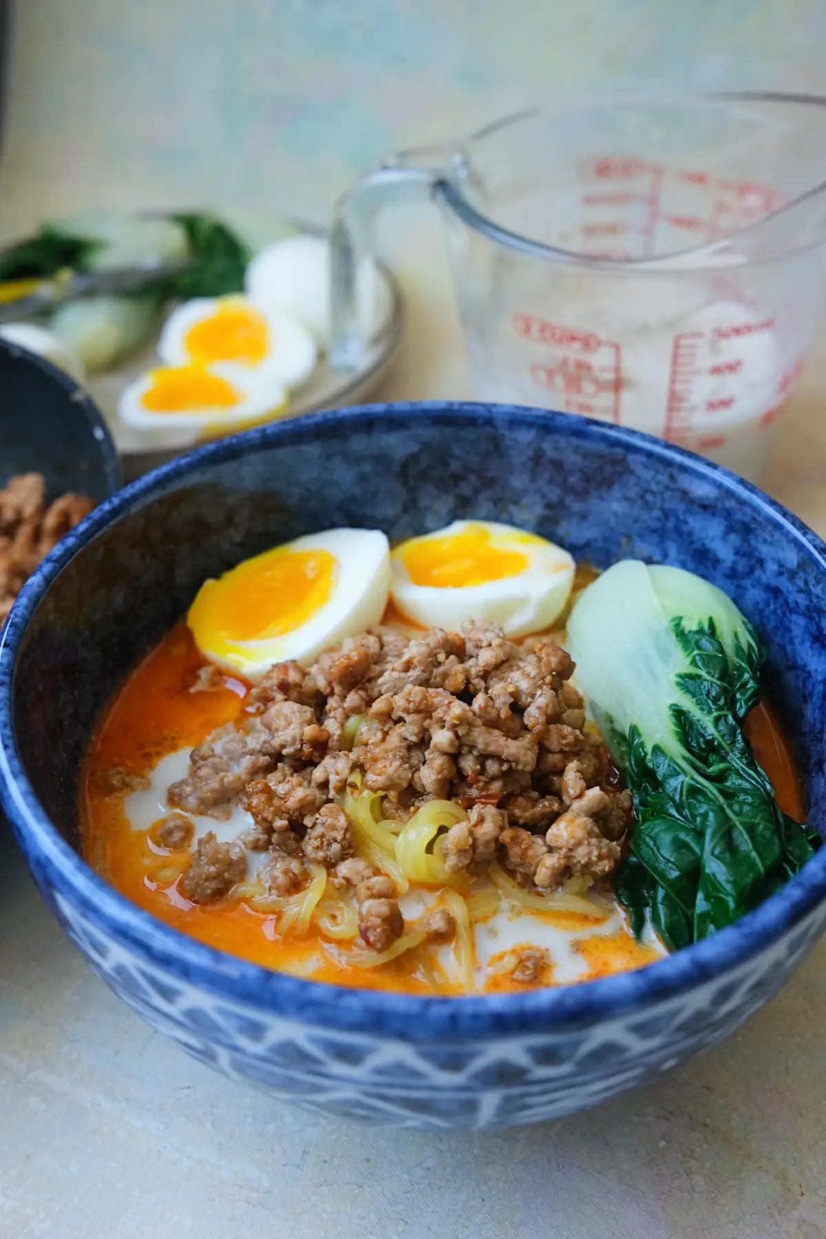 Homemade tantanmen ramen topped with seasoned ground pork, soft-boiled egg, and baby bok choy in a creamy sesame broth