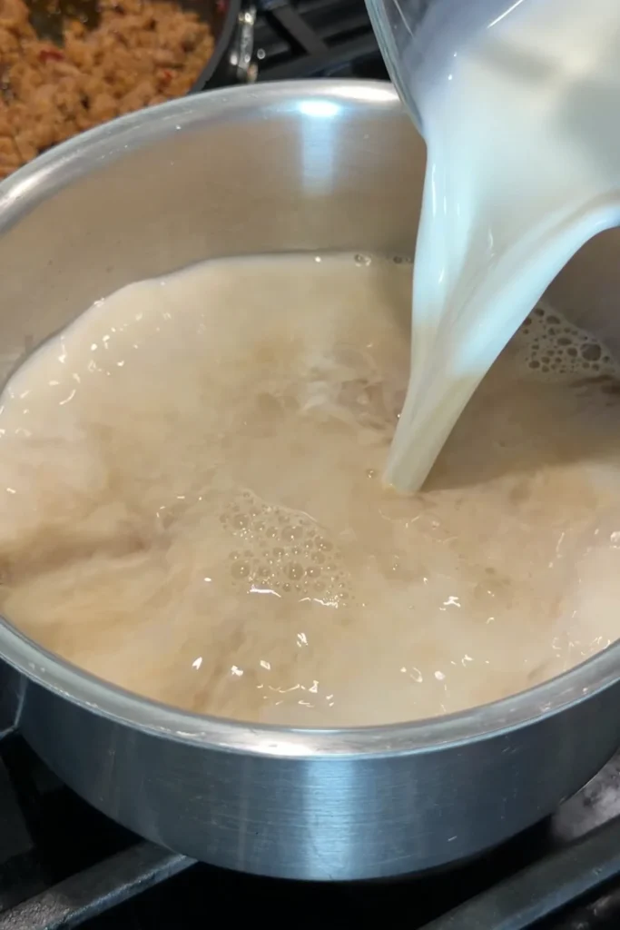 Whole milk being added to dashi broth for a rich and creamy tantanmen soup base