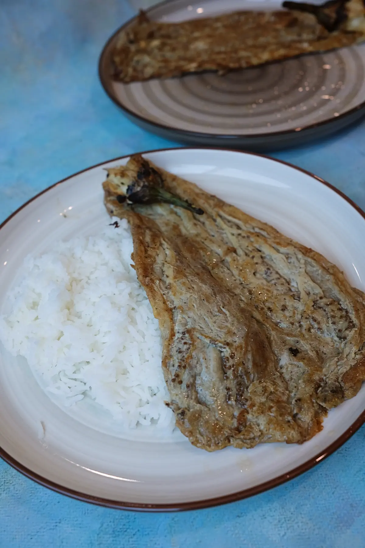 Golden tortang talong served with a side of steamed white rice.