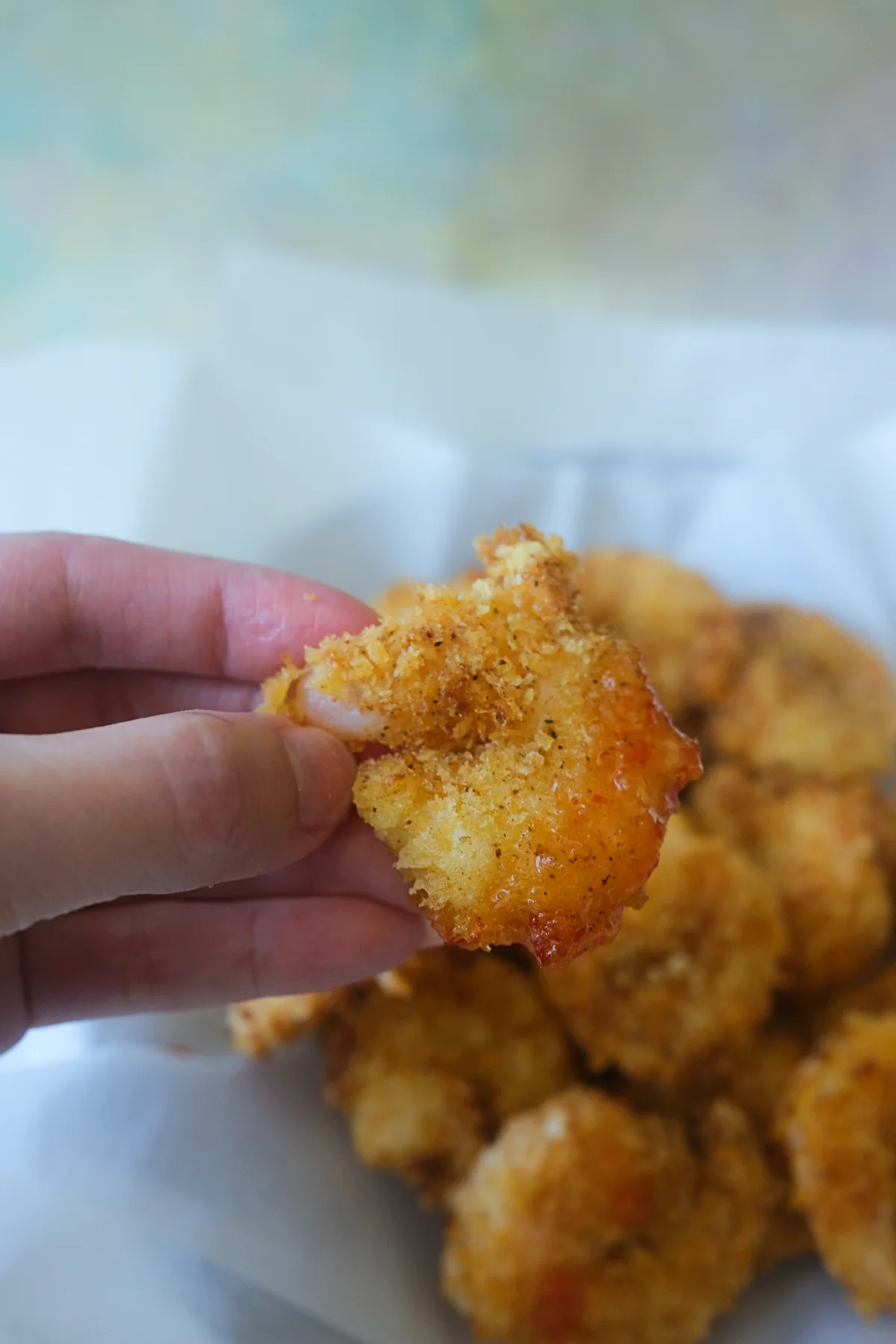 Close up of crispy air fryer popcorn shrimp dipped in sweet chili sauce with golden panko coating