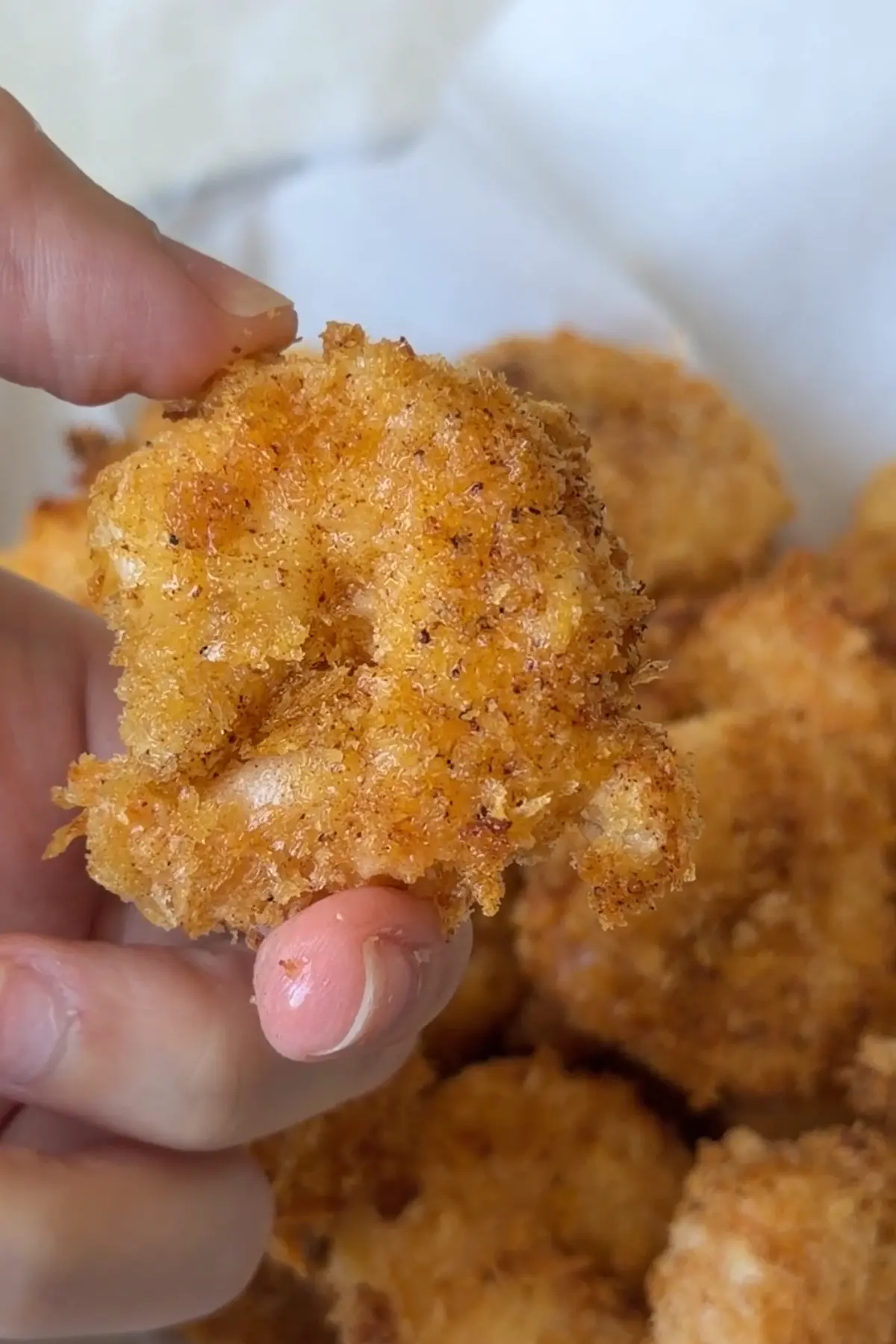 Close up of crispy air fryer popcorn shrimp showing golden panko crust
