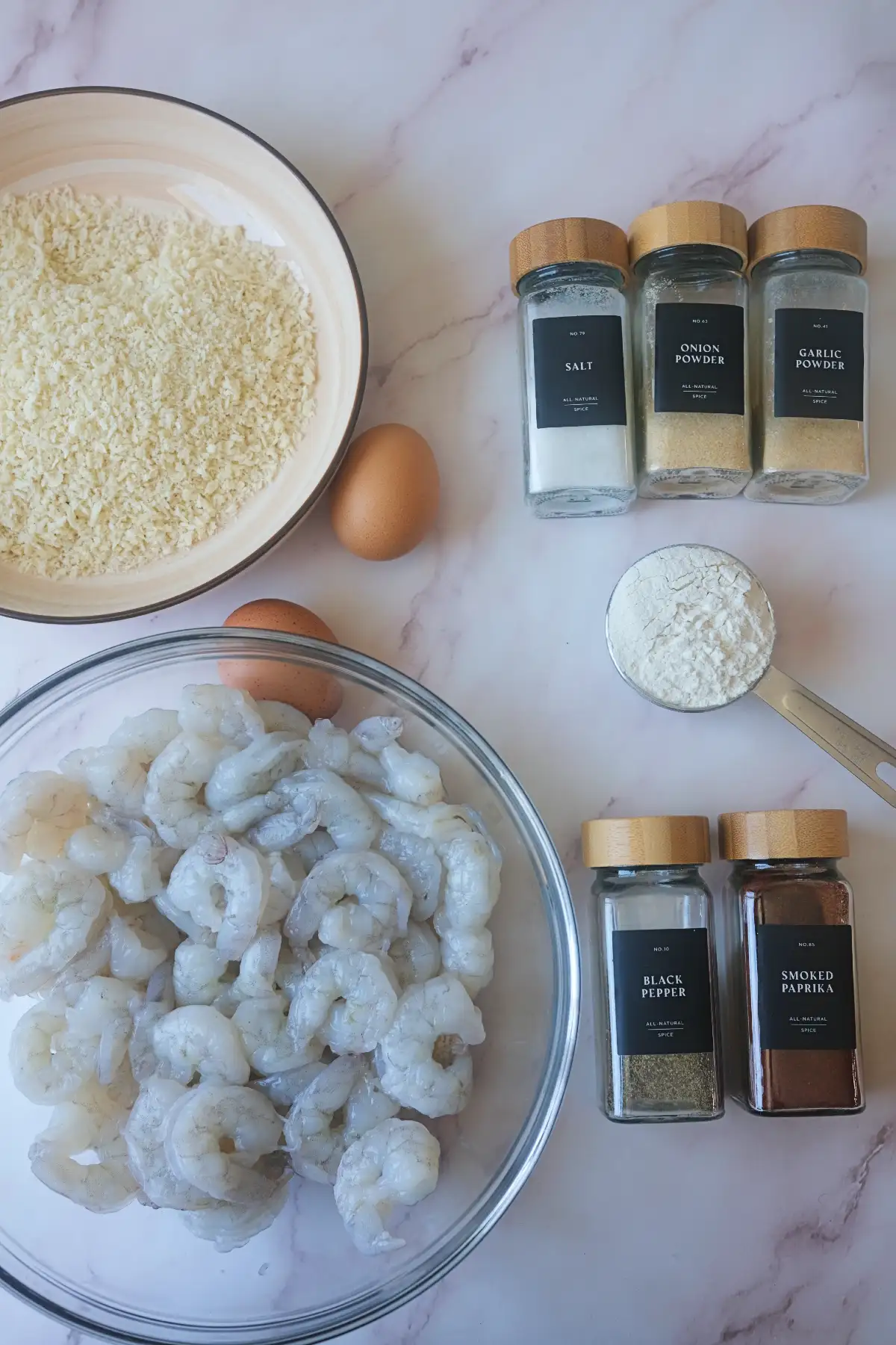 Ingredients for air fryer popcorn shrimp with raw shrimp, panko breadcrumbs, eggs, flour, and seasonings