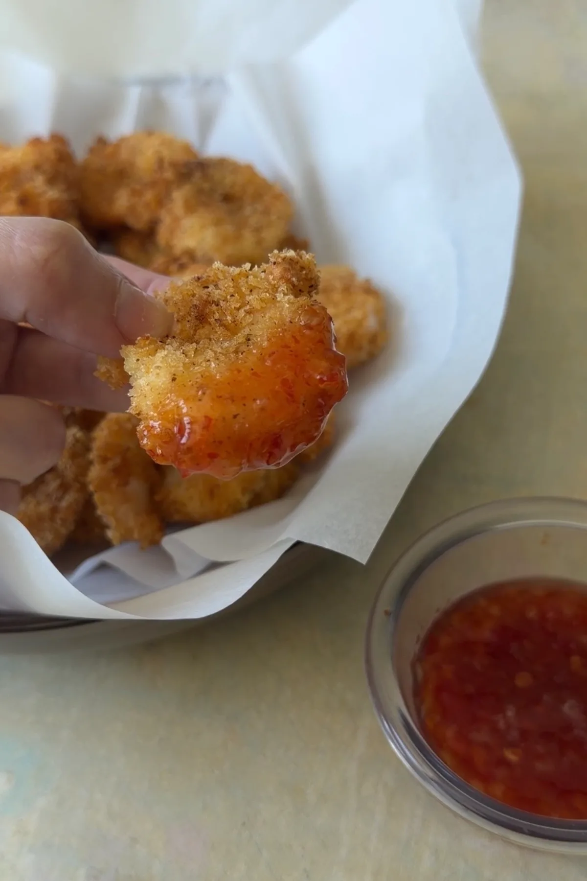 Crispy air fryer popcorn shrimp dipped in sweet chili sauce with golden panko coating