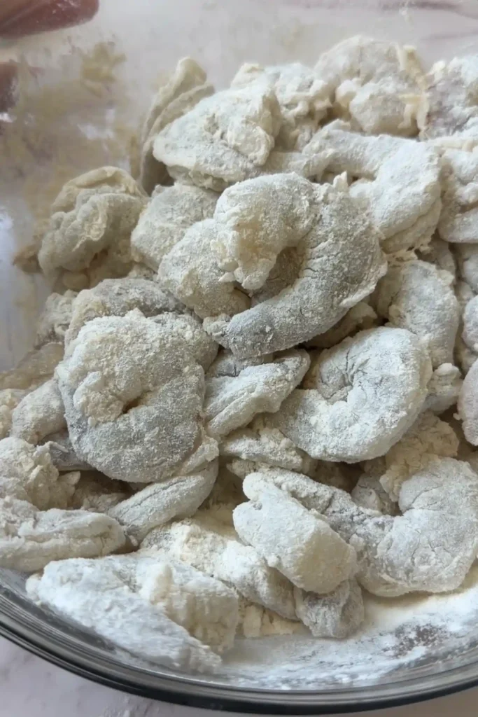 Shrimp coated in flour mixture before breading for air fryer popcorn shrimp