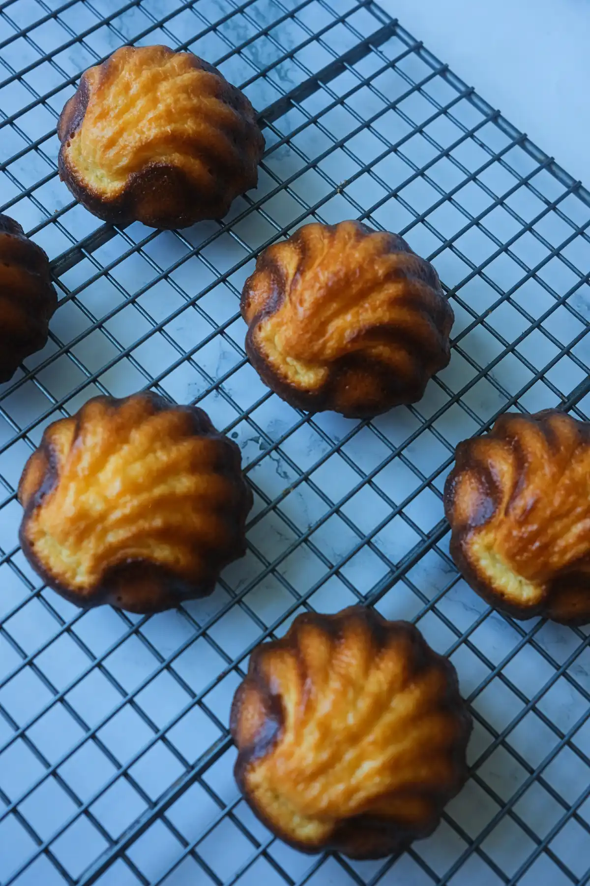 Freshly baked butter tteok cooling on a wire rack.