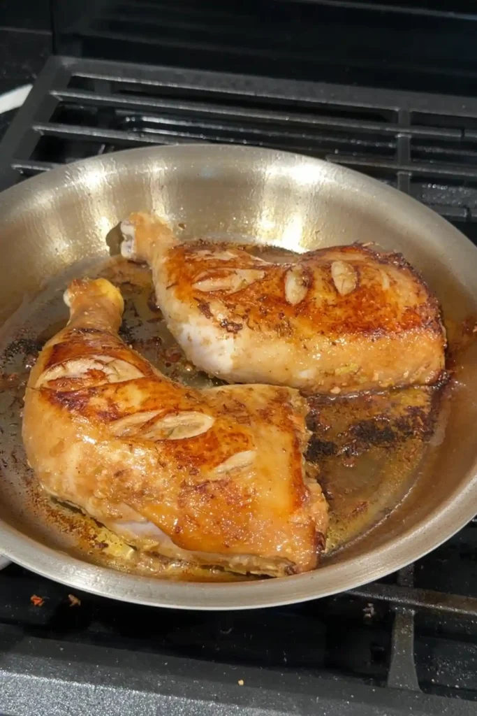 Searing Chicken Inasal in a skillet until the skin is golden brown