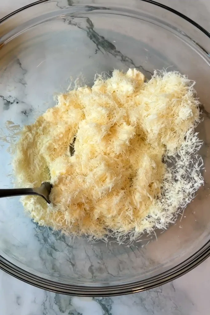 Whole milk ricotta and finely grated Parmesan combined in a glass mixing bowl before adding the pasta.