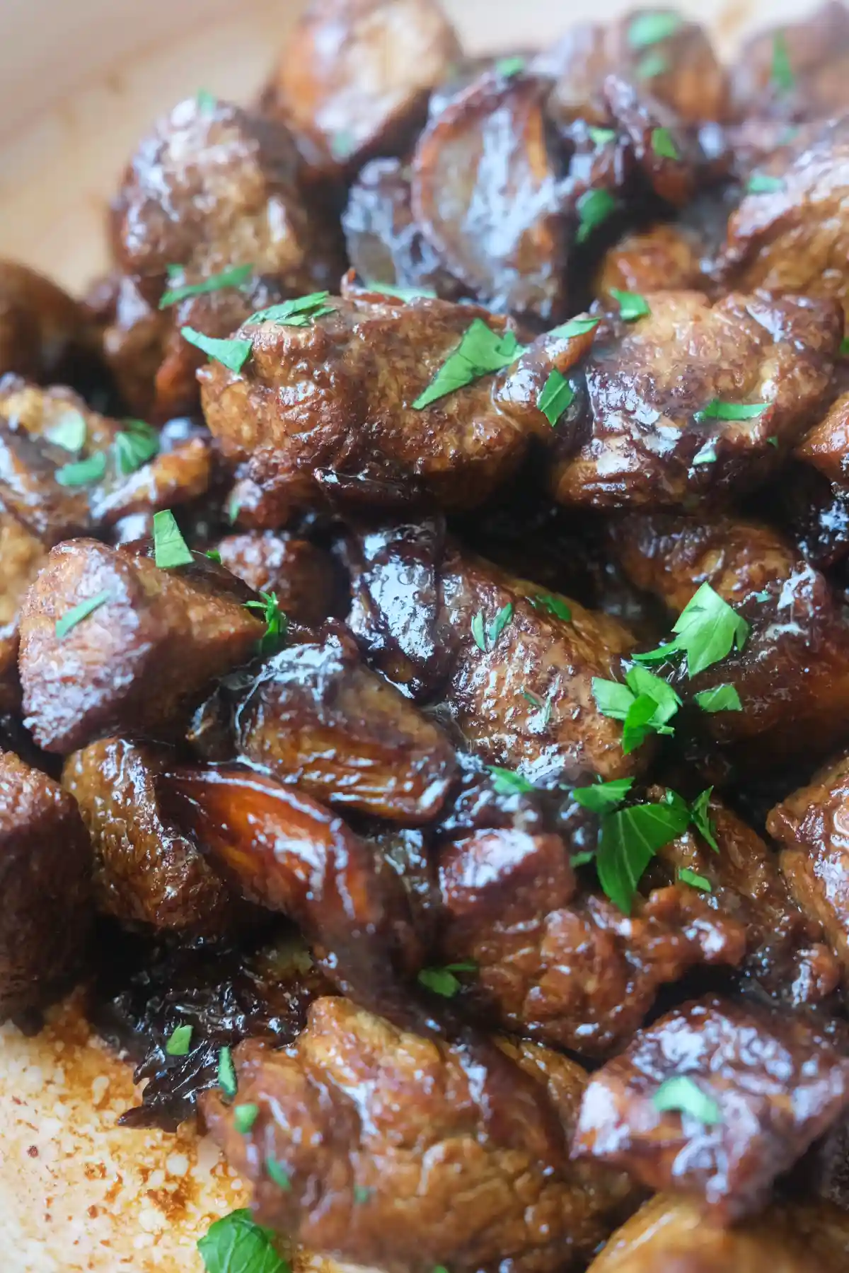 Close-up of pork salpicao made with tender pork loin, garlic, and chopped parsley in a serving dish.
