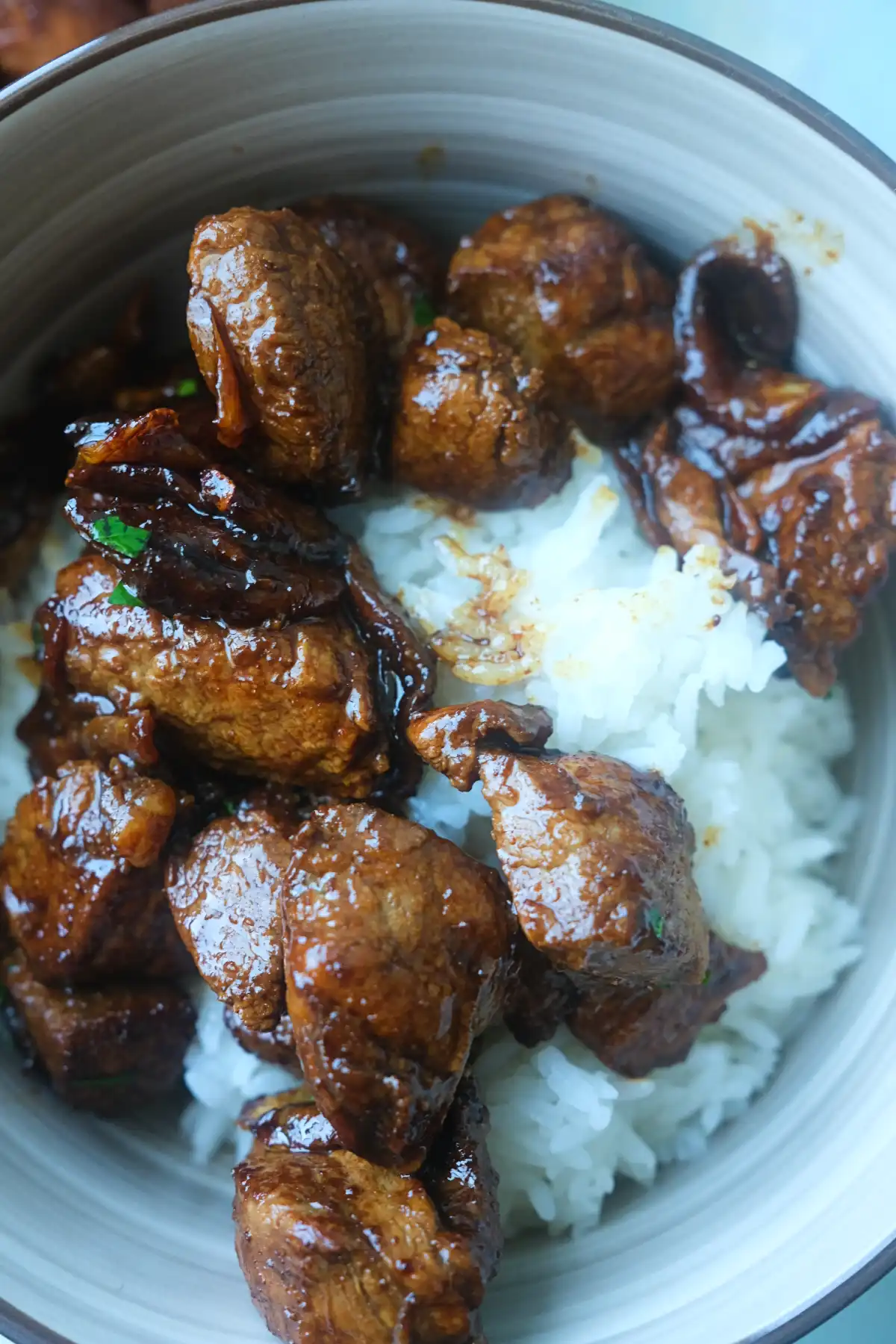 Bowl of steamed white rice topped with pork salpicao, crispy garlic, and a rich garlic butter soy sauce.