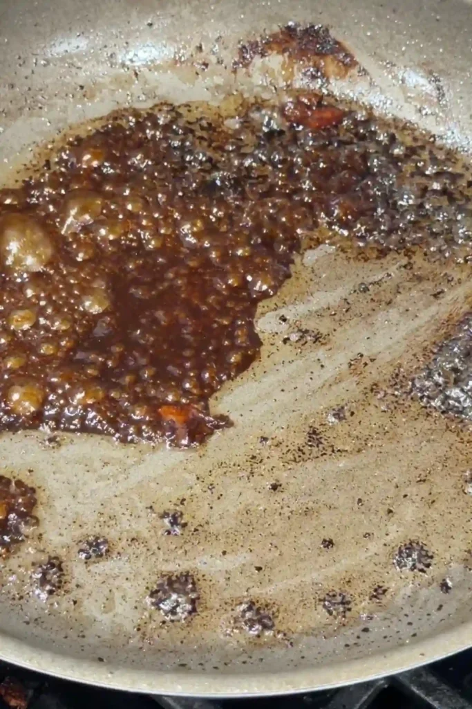 Garlic butter soy sauce simmering in a skillet until slightly thickened and glossy.