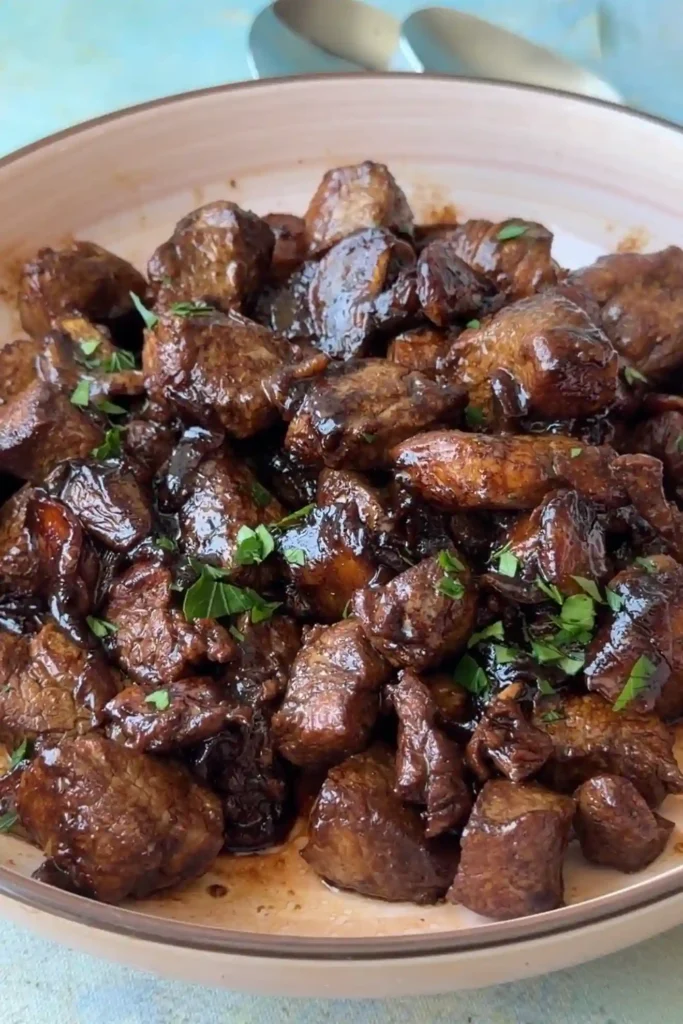 Pork salpicao garnished with chopped parsley and served in a shallow dish.