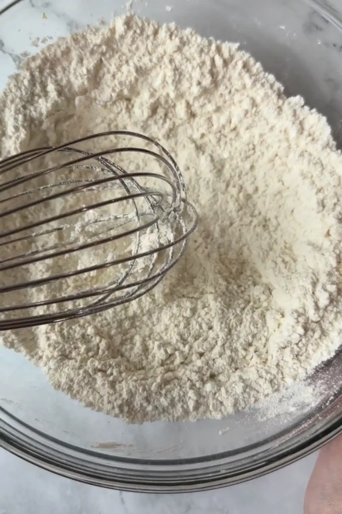 Dry ingredients whisked together in a glass mixing bowl.