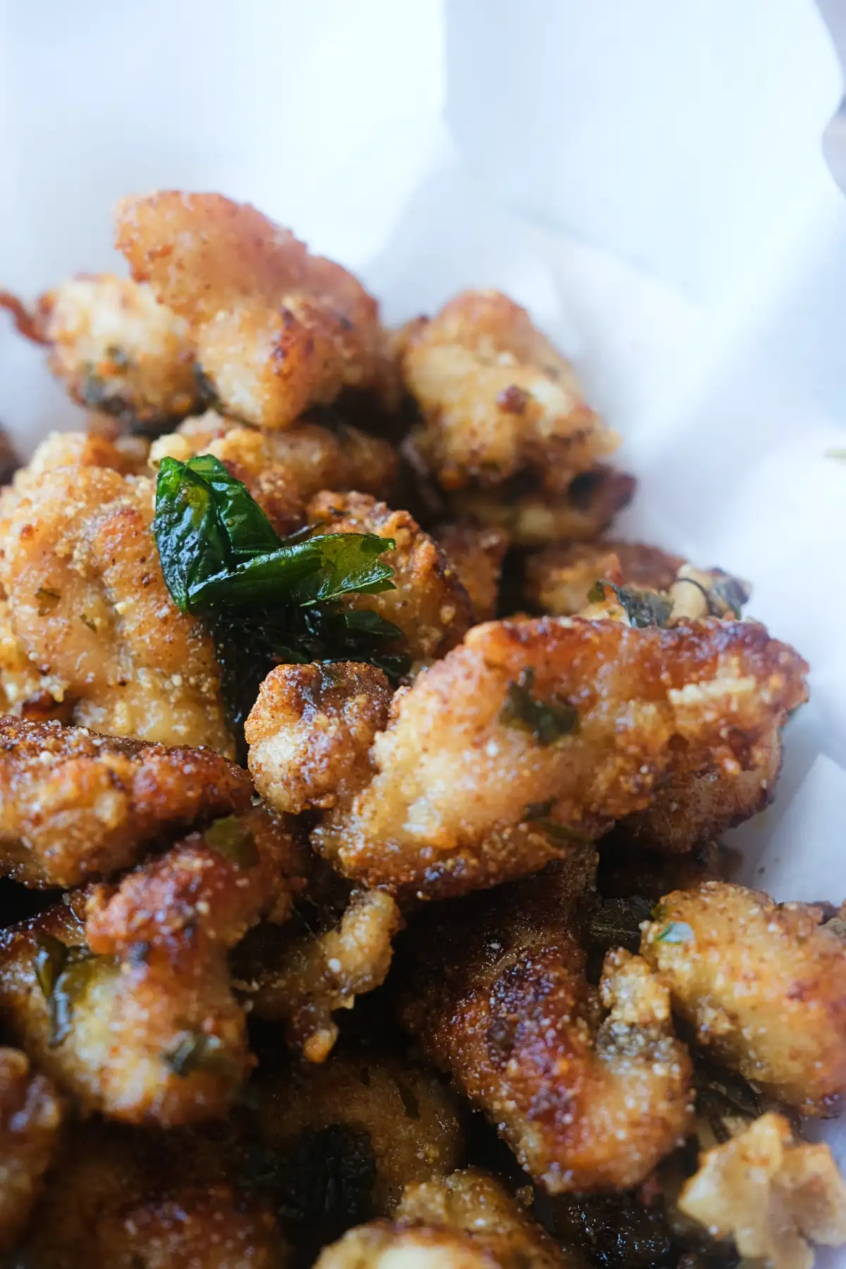 Close-up of Taiwanese popcorn chicken with a light, crispy coating and bits of fried basil.