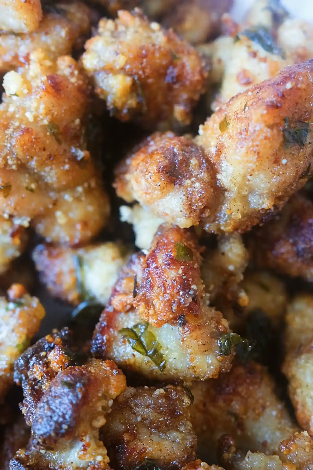 Close-up of Taiwanese popcorn chicken with a golden crispy coating and fried basil on top.