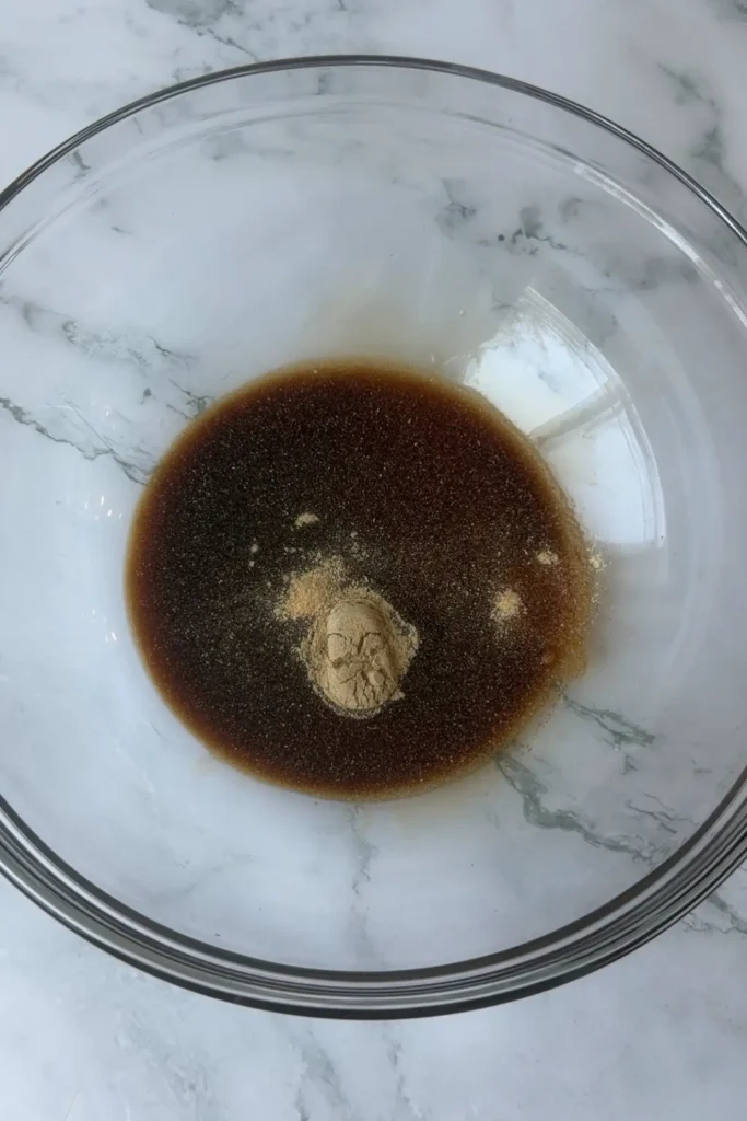 Soy sauce, mirin, garlic powder, white pepper, and egg white in a glass bowl for the Taiwanese popcorn chicken marinade.