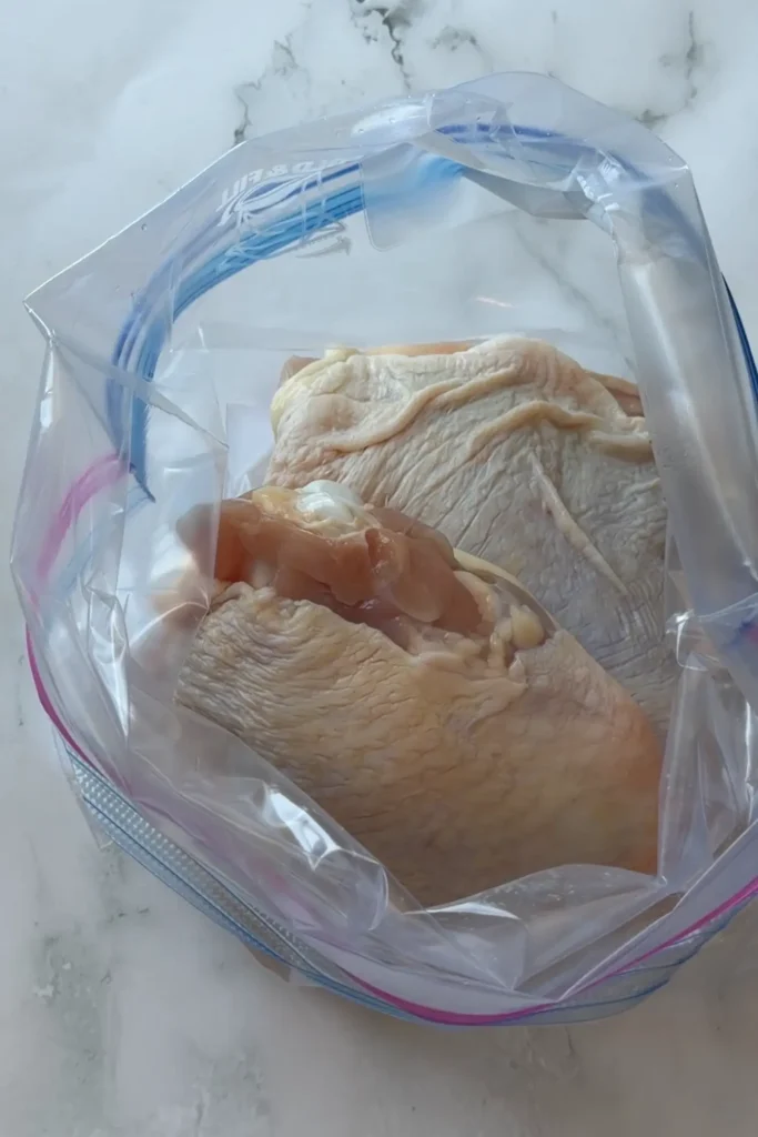 Bone-in, skin-on chicken thighs placed inside a zip-top bag before adding the Vietnamese lemongrass marinade for marinating.