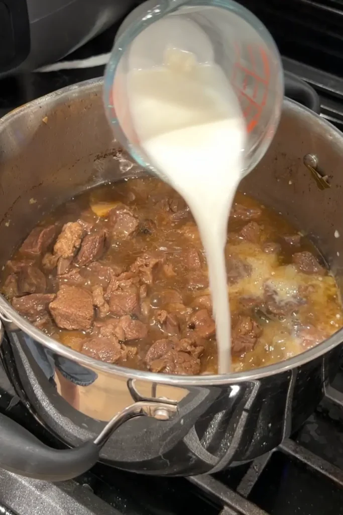 Cornstarch slurry being poured into the beef pares to thicken the sauce.