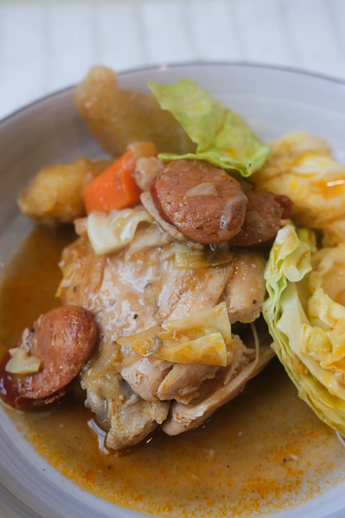 Filipino chicken pochero with chorizo, cabbage, carrots, and saba bananas