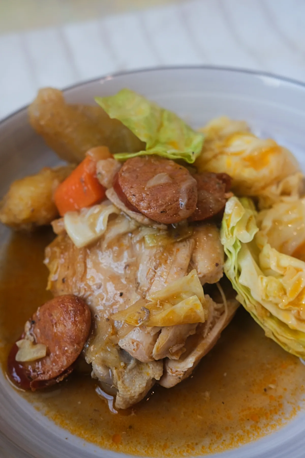 Chicken pochero with tender chicken, Chorizo de Bilbao, cabbage, and tomato broth