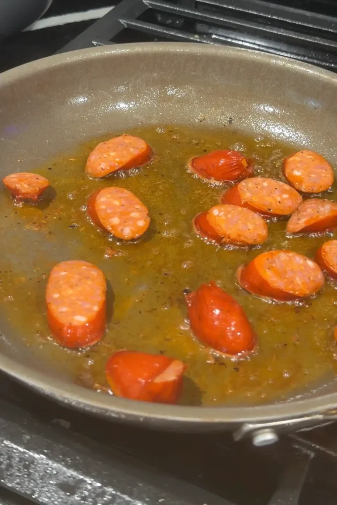 Sliced Chorizo de Bilbao sautéing in a pan for chicken pochero
