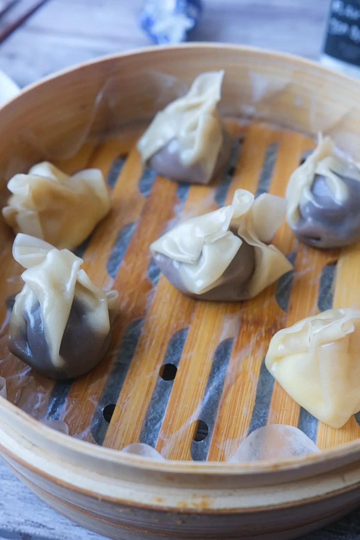 Steamed chocolate dumplings made with wonton wrappers arranged in a parchment-lined bamboo steamer.