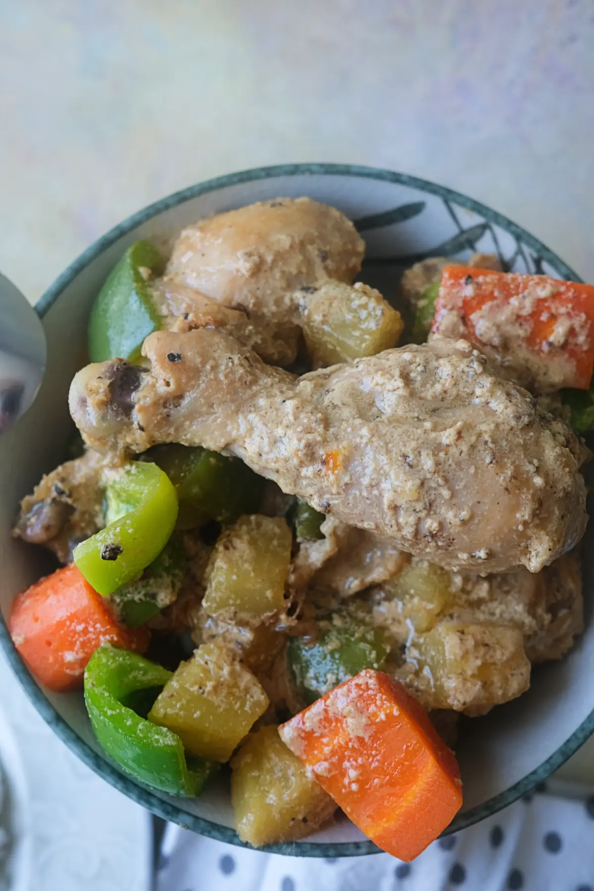Creamy Pininyahang Manok with tender chicken, pineapple, carrots, and green bell peppers in a serving bowl.