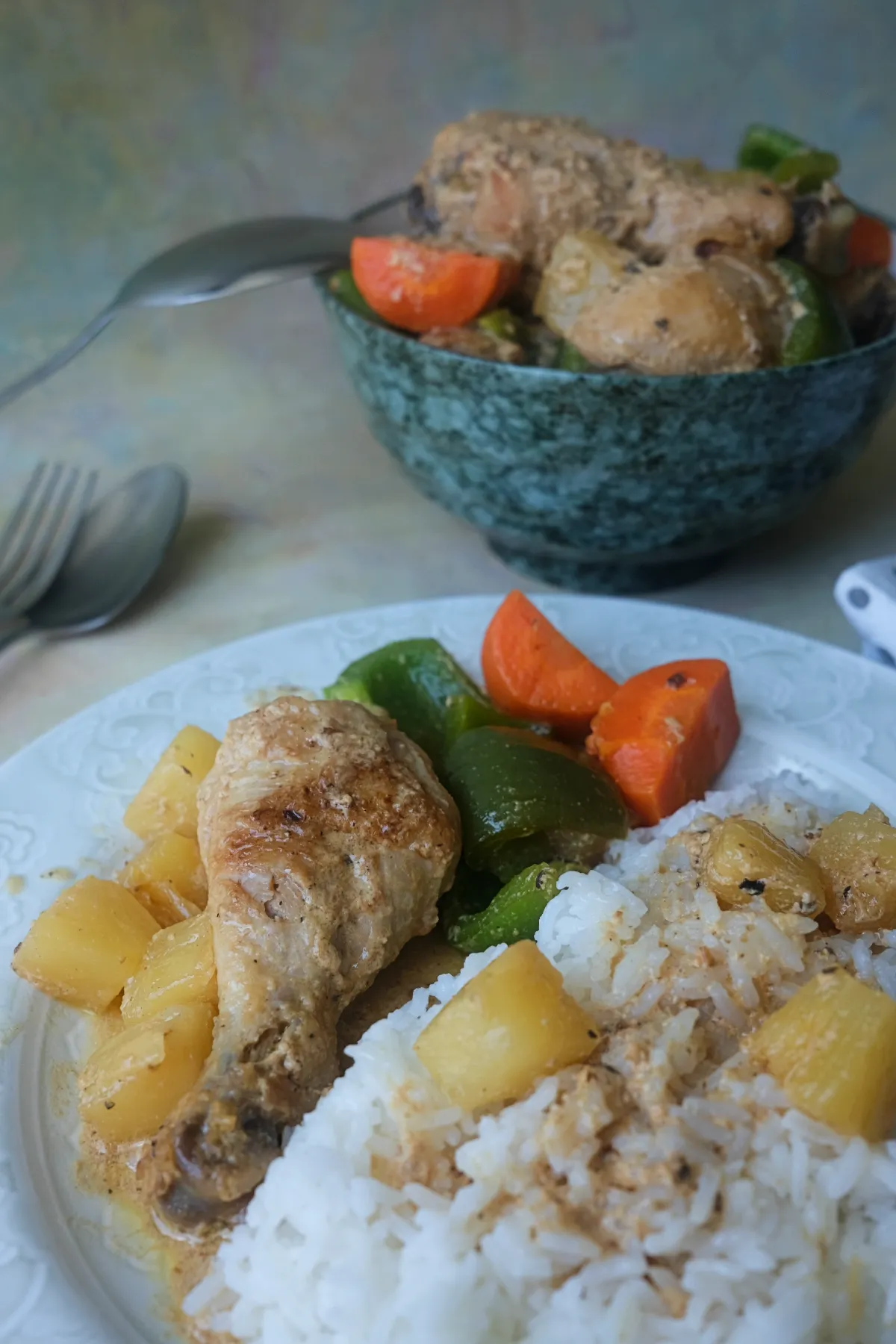 Filipino pineapple chicken served with steamed rice, pineapple chunks, carrots, and green bell peppers.