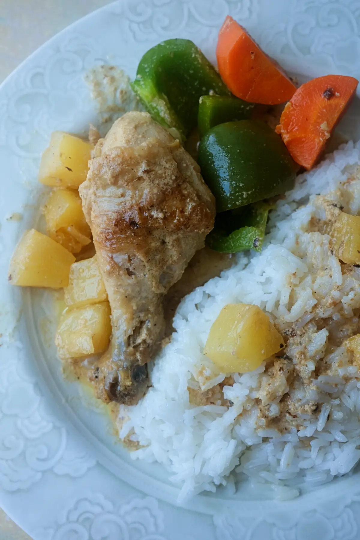 Plate of Pininyahang Manok with pineapple, carrots, green bell peppers, and steamed white rice.