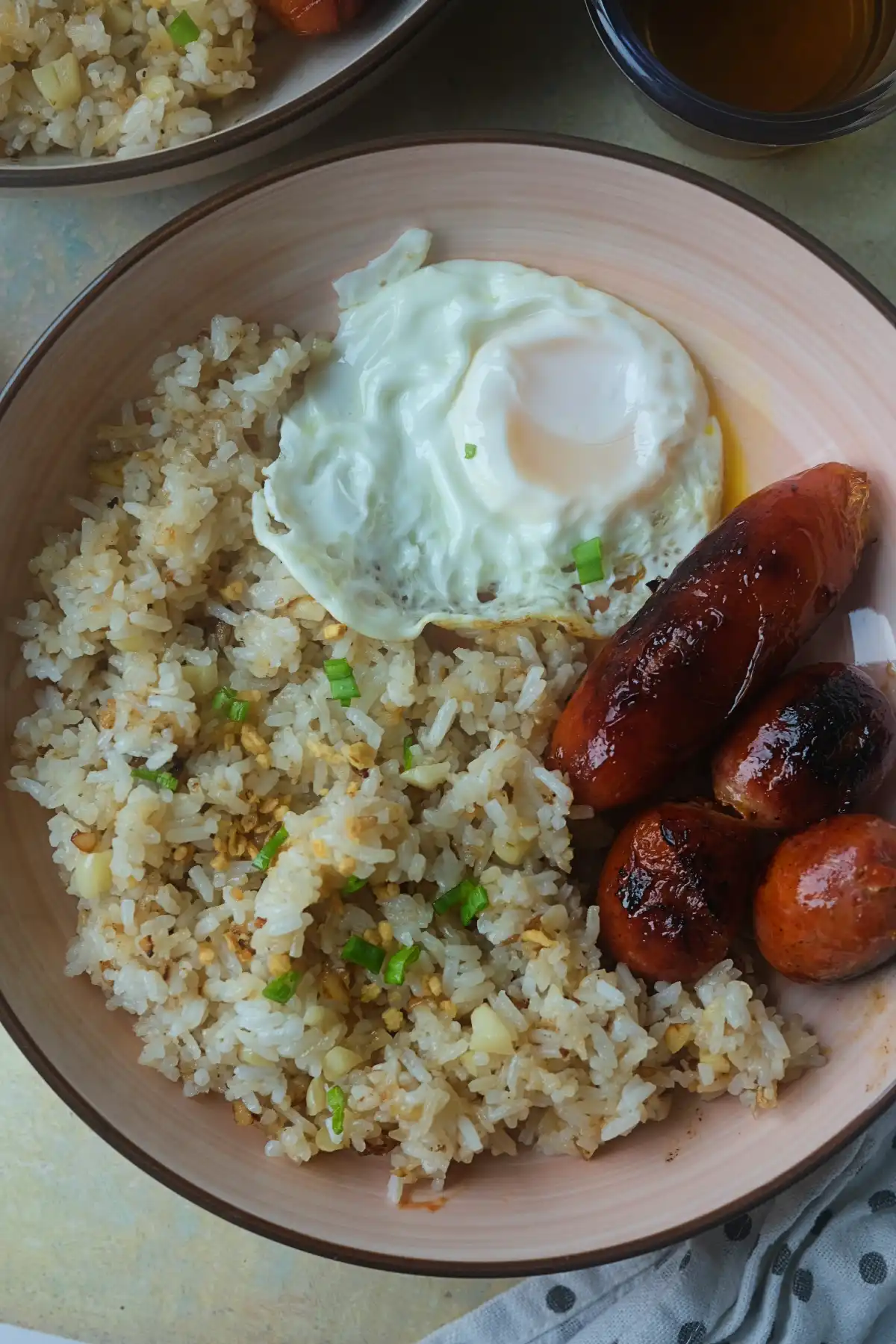 Filipino silog with garlic fried rice, fried egg, and longganisa served in a bowl