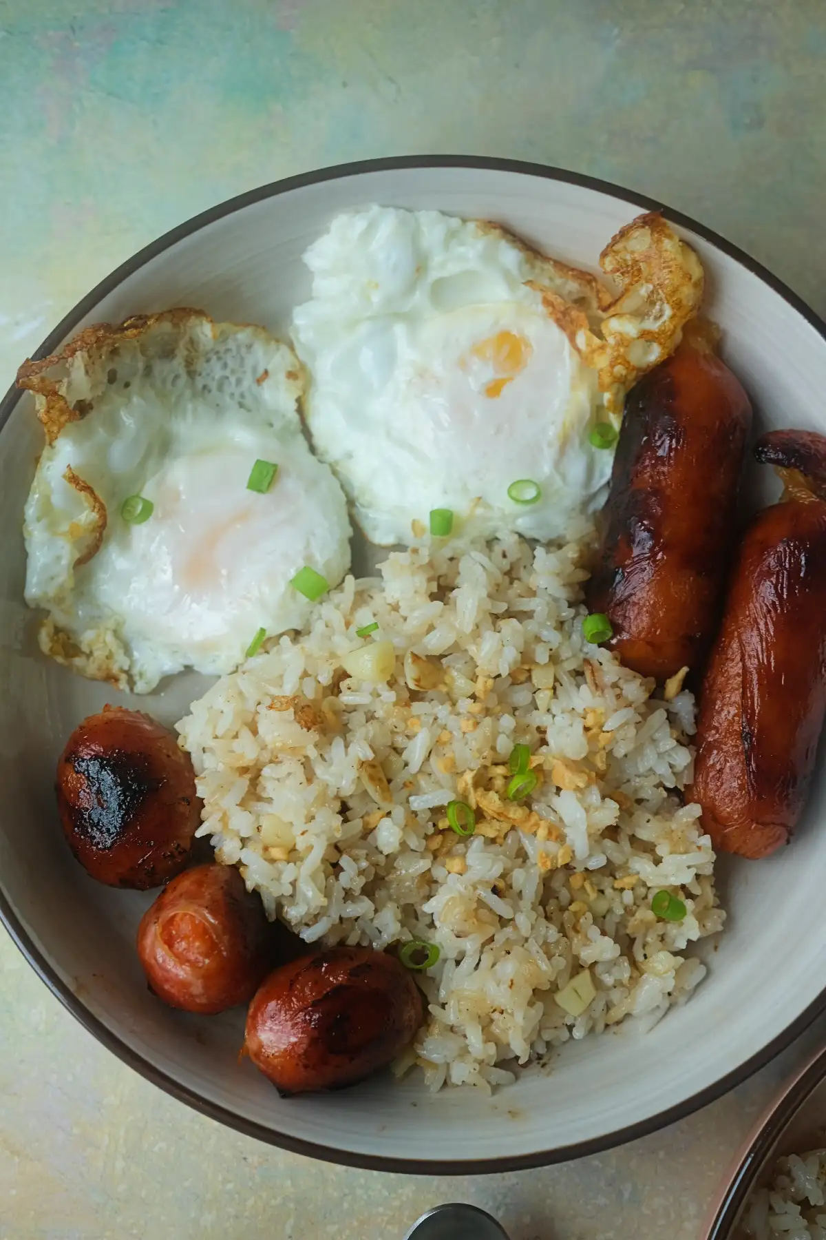 Longsilog with garlic fried rice, crispy fried eggs, and browned longganisa