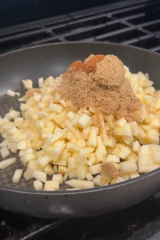Diced apples with brown sugar and cinnamon in a skillet for apple turon filling.