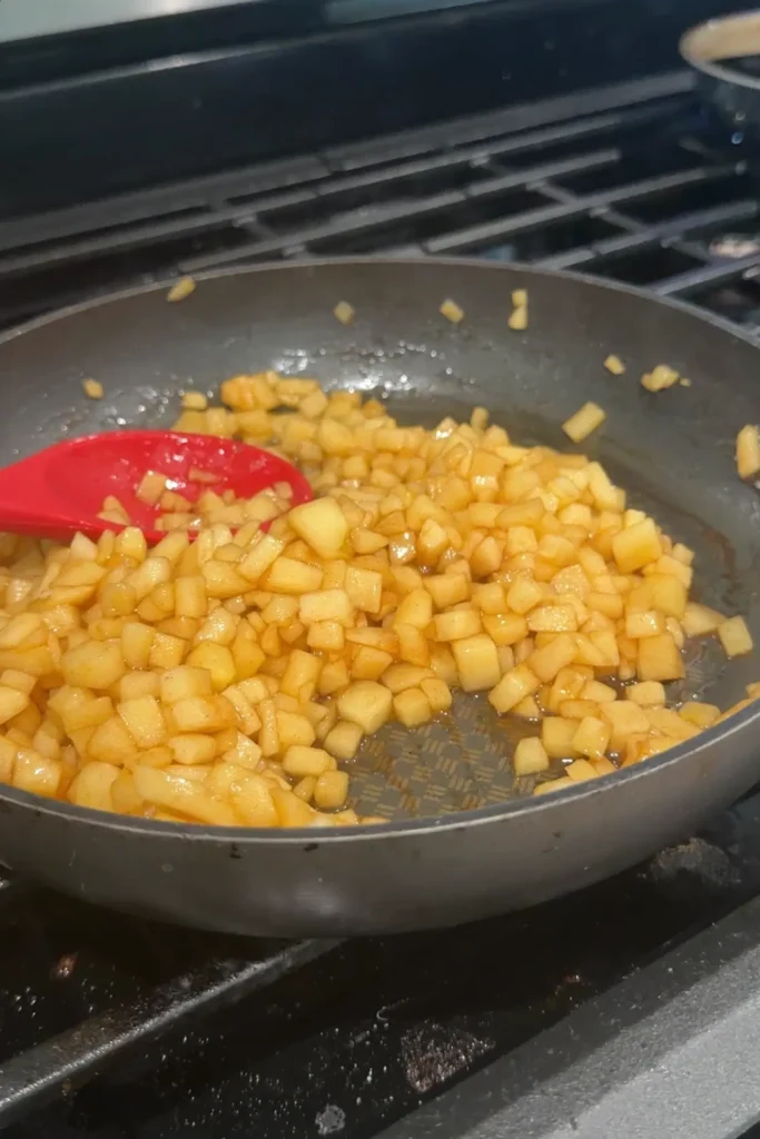 Cinnamon apples cooking with brown sugar and butter in a skillet for apple turon.