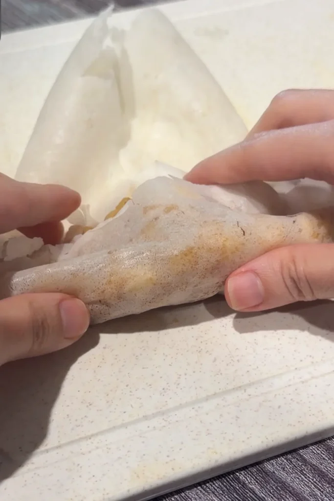 Folding a lumpia wrapper around the cinnamon apple filling to make apple turon.