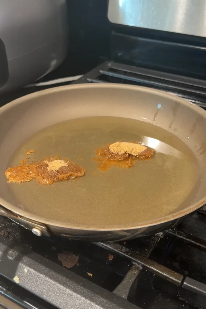 Brown sugar added to hot oil in a skillet for the caramelized turon coating.