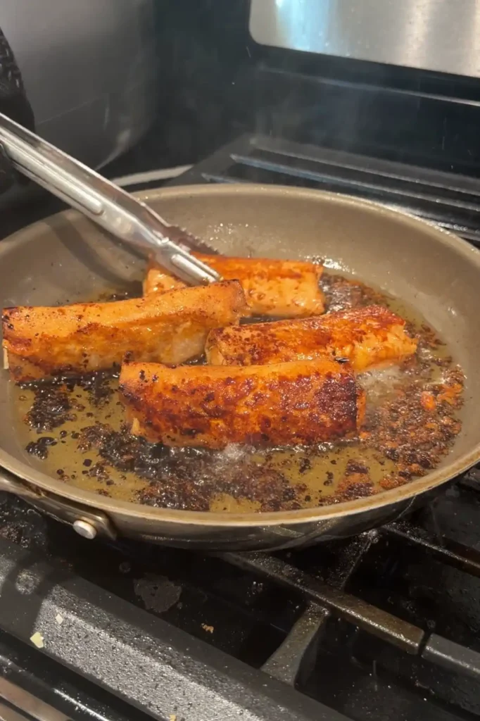 Golden apple turon frying in caramelized brown sugar until crisp.