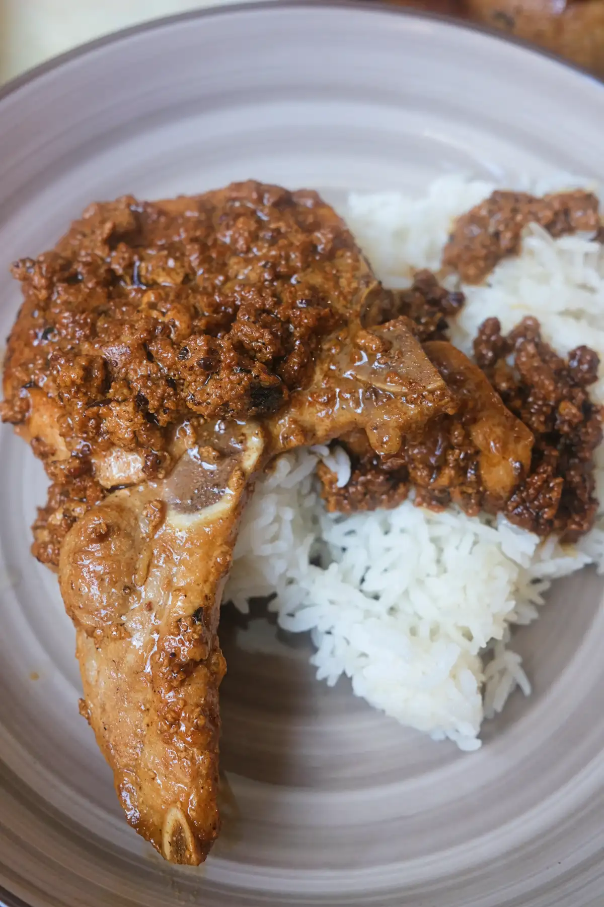 Bone-in creamy pork chop topped with savory milk curds and served with white rice.