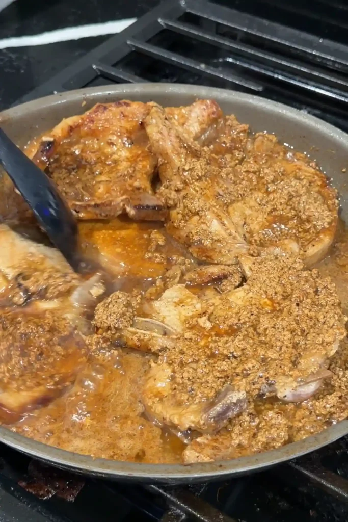 Pork chops simmering in the evaporated milk marinade as it begins to form curds.