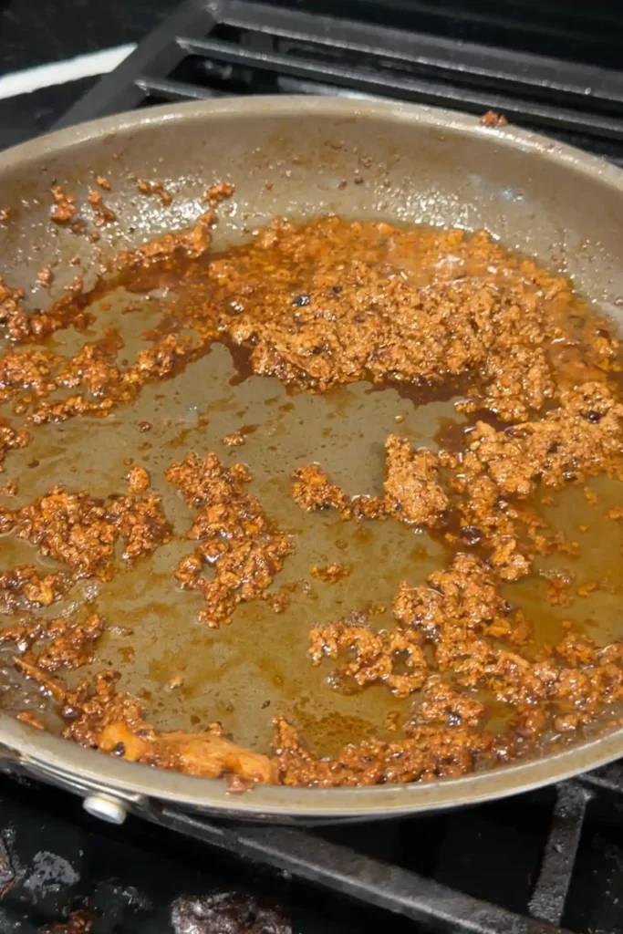 Savory browned milk curds left in the skillet after the marinade has fully reduced.