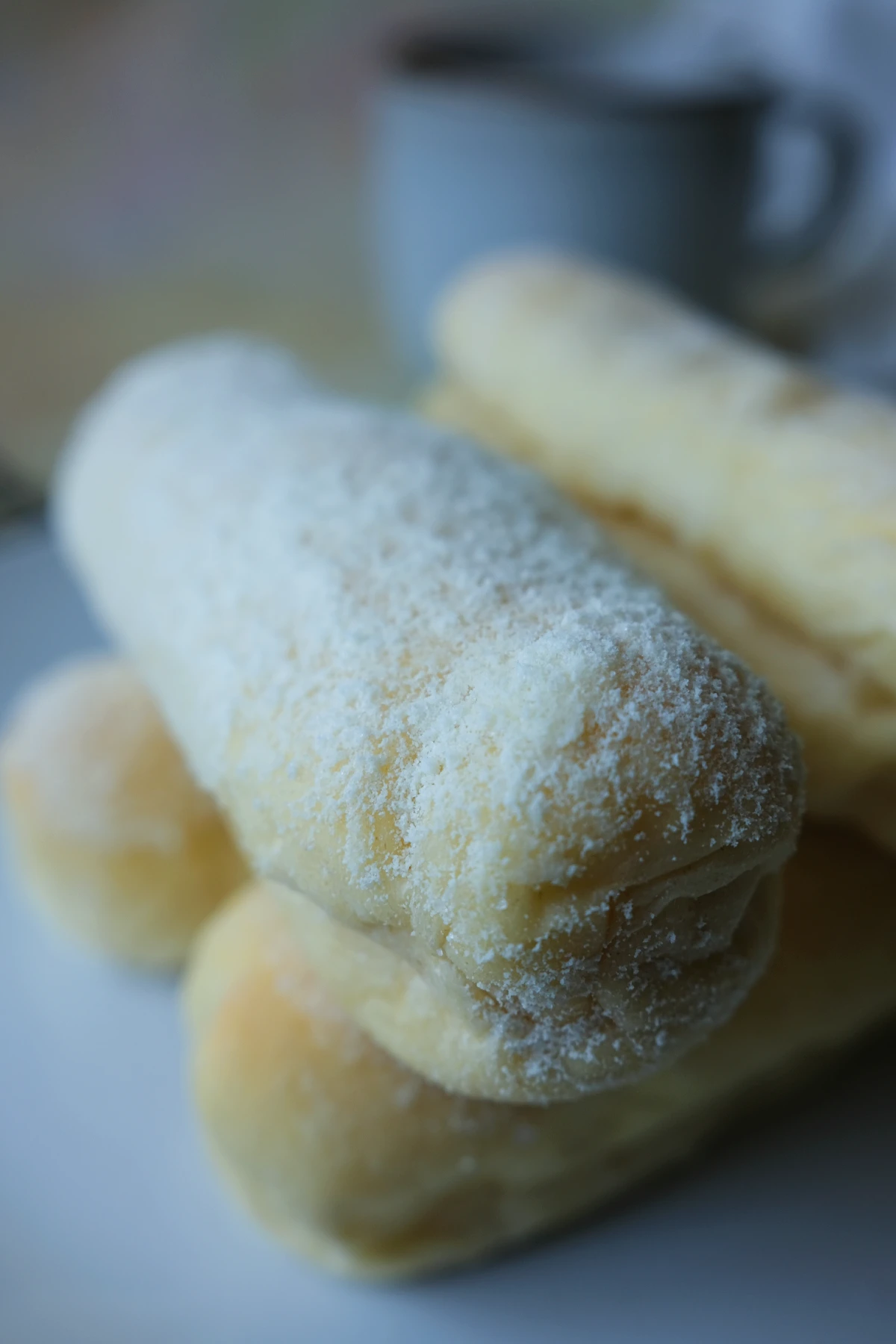 Close-up of a Filipino cheese roll coated with milk powder and sugar.