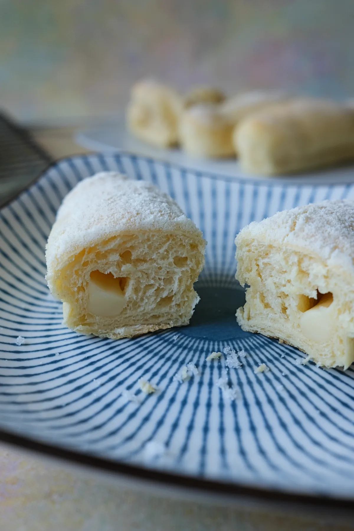 Filipino cheese roll cut open to show its soft, airy bread and cheese center.