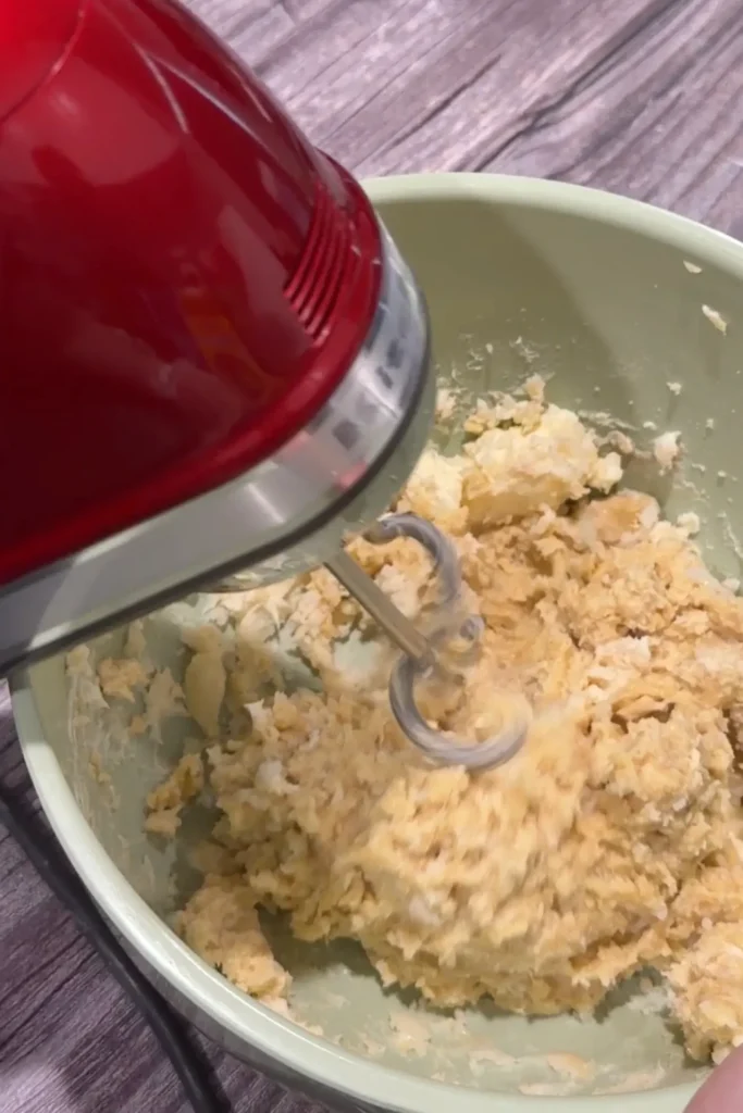 Mixing Filipino cheese roll dough with an electric hand mixer and dough hooks.
