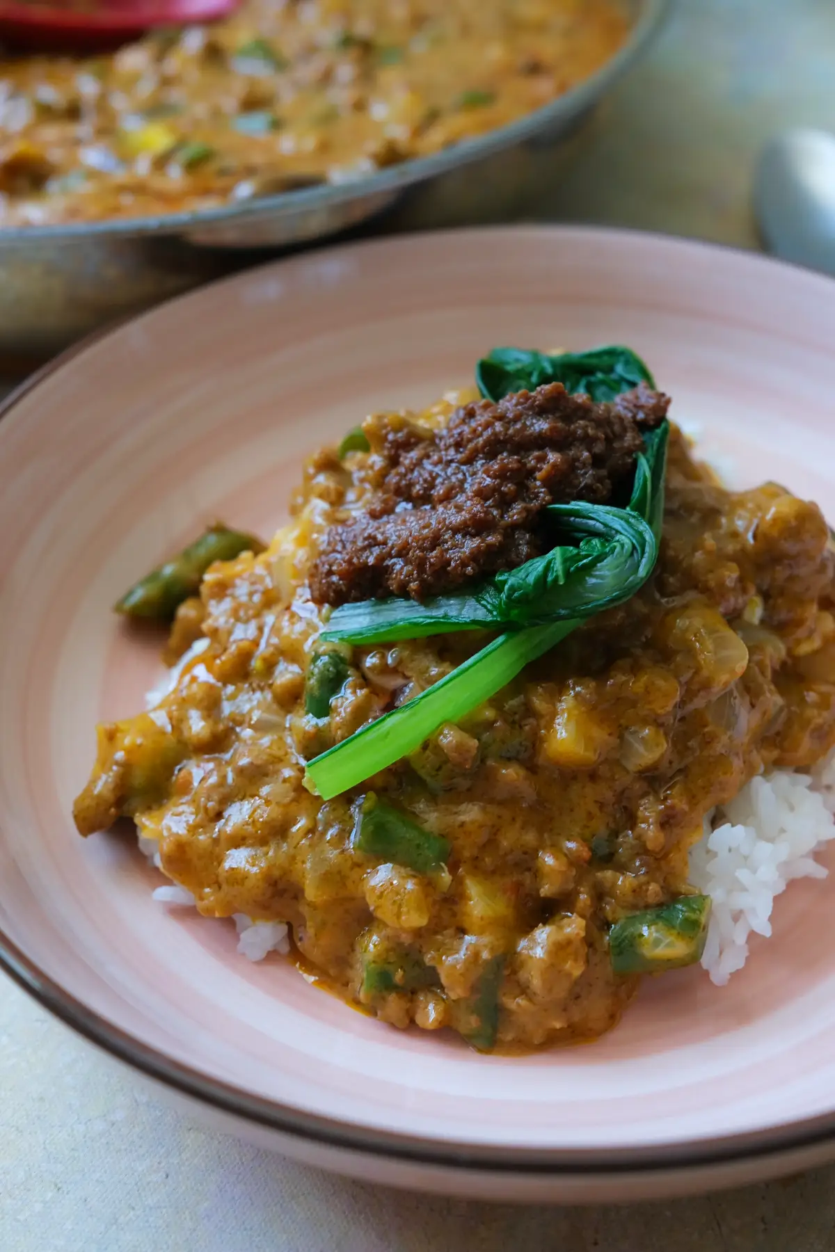 Ground beef kare kare in a rich peanut sauce served with white rice, bok choy, and bagoong.