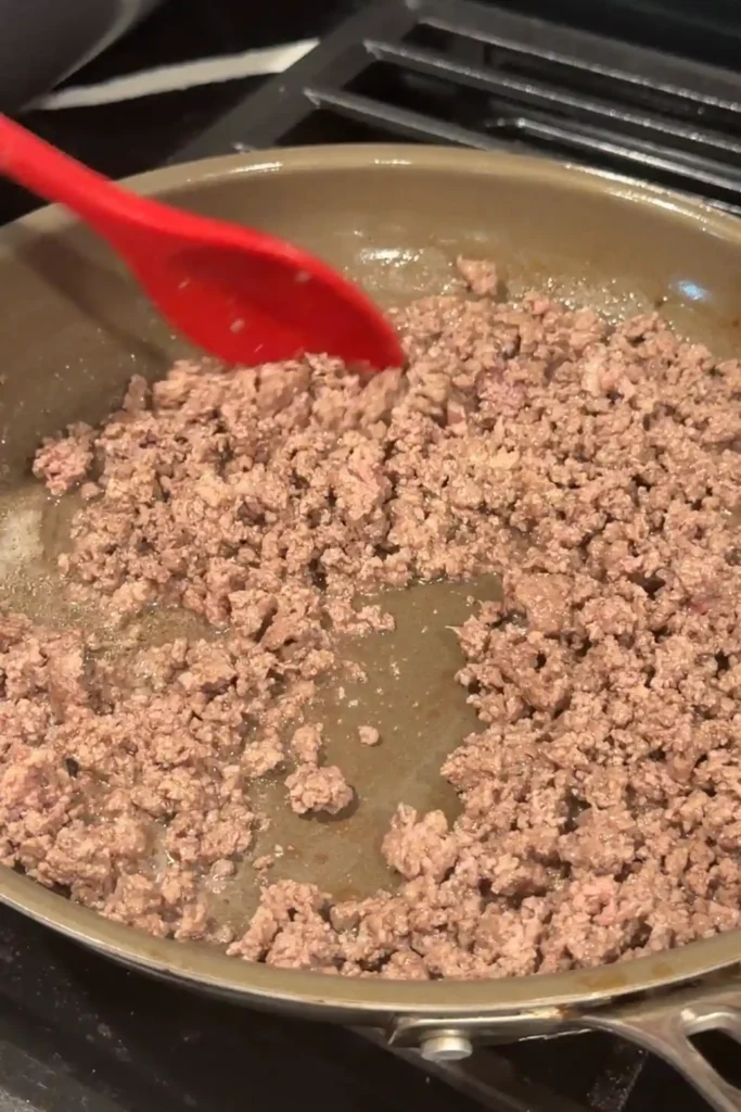 Cooked ground beef crumbled in a skillet.