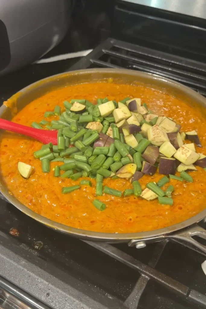 Chopped eggplant and long beans added to the ground beef kare kare.