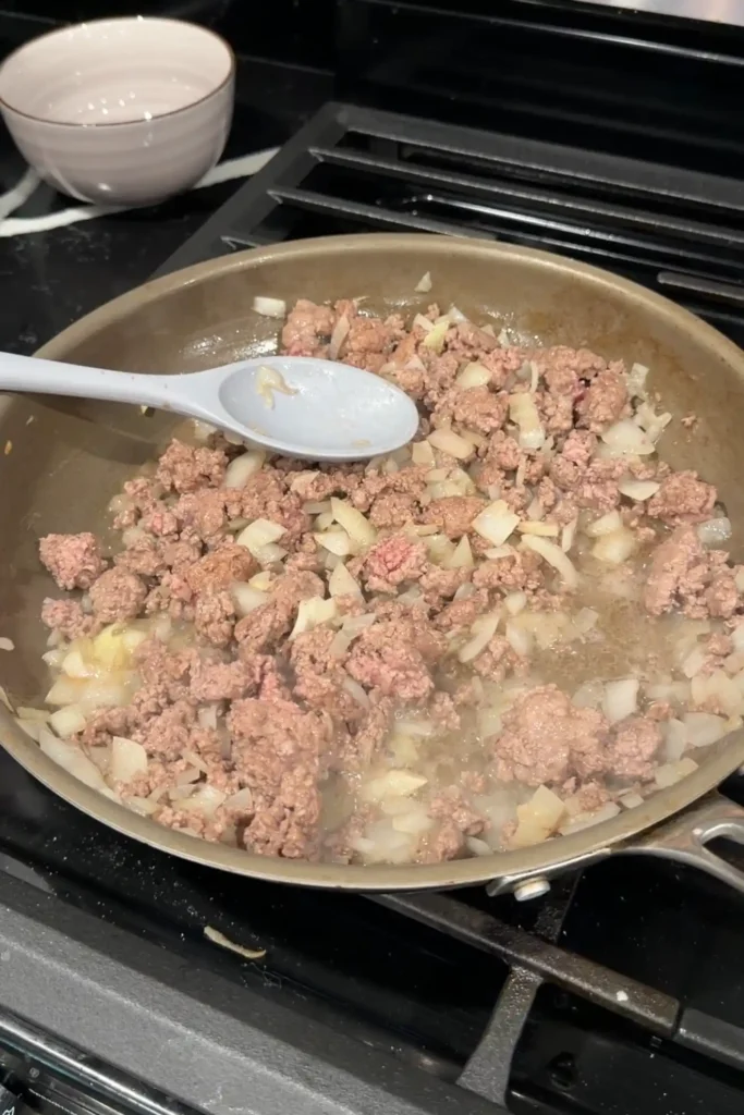 Ground beef and onions cooking together until browned.